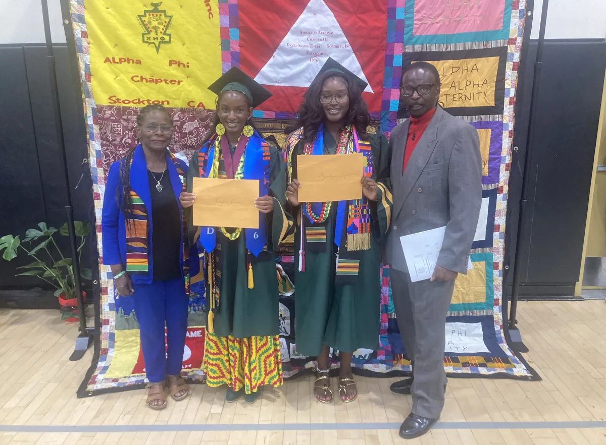 Ameni with graduates and a community member at a graduation celebration